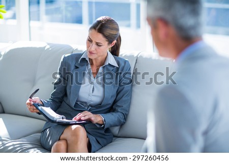 Business people speaking together on couch in office