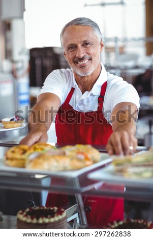 Barista smiling at camera behind counter in the bakery