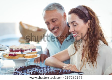 Cute couple looking at pastries in the bakery store