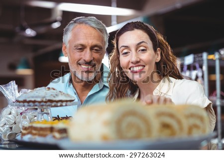 Cute couple looking at cakes in the bakery store
