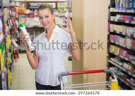 woman taking a rice bag in the shelf of aisle at supermarket