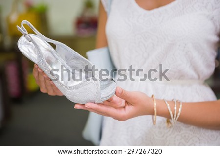 Woman looking at high-heeled sandals at a shoe shop