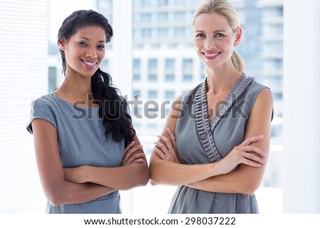 Side to side businesswomen looking at the camera in the office