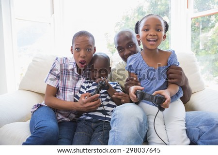 Happy smiling family playing video games together in the living room