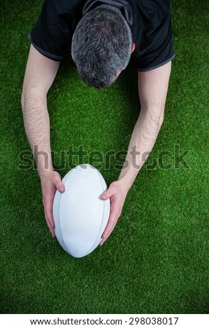 Upward view of a rugby player scoring a try