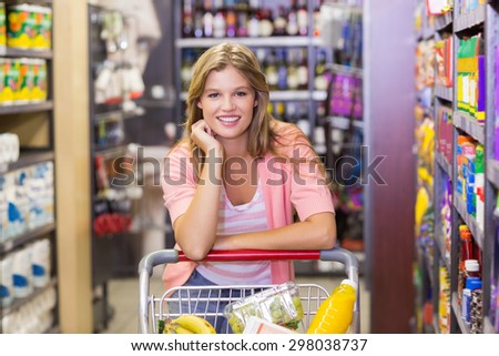 Portrait of a smiling pretty blonde woman buying products in supermarket