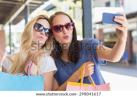 Happy friends taking a selfie while doing funny faces