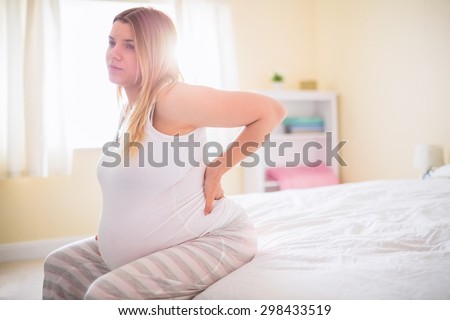 Pregnant woman with back pain at home