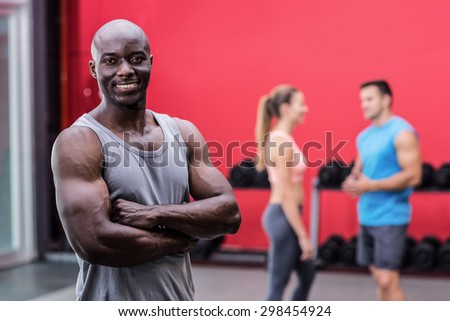 Portrait of a smiling muscular man with arms crossed