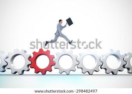 Businessman running with a suitcase against red and white cogs and wheels