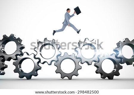 Businessman running with a suitcase against metal cogs and wheels connecting