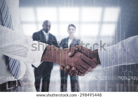 Close-up shot of a handshake in office against stocks and shares