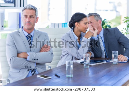 Sad businessman looking aways while his colleagues speaks in office