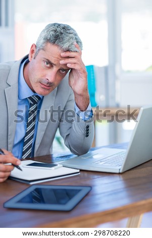 Depressed businessman trying to work in office