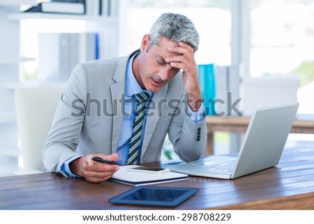 Irritated businessman trying to work in office