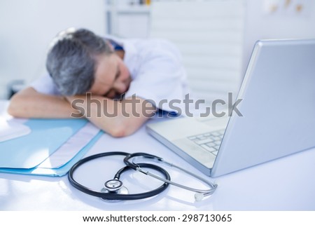 Female doctor sleeping on desk in medical office