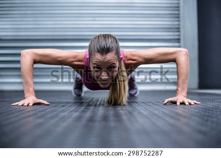 Portrait of a muscular woman doing push ups