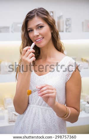 Portrait of smiling woman testing lipstick at a beauty salon