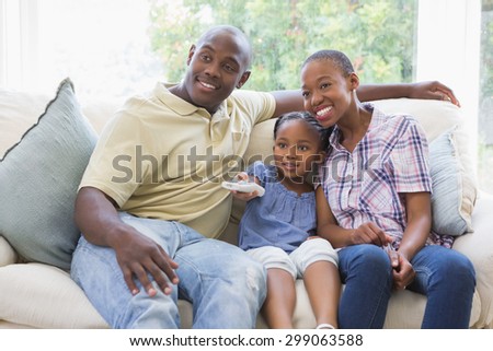Happy smiling family watching television in living room
