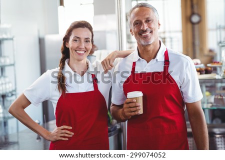Two baristas smiling at the camera at the cafe