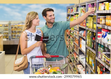 Smiling bright couple buying food products at supermarket