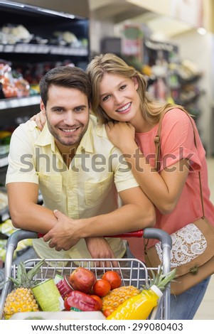Portrait of smiling bright couple buying products at supermarket