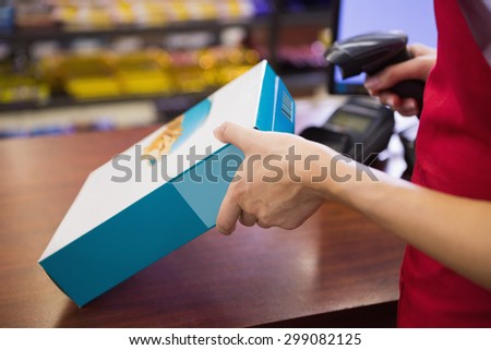 Female worker scanning cereal box at supermarket