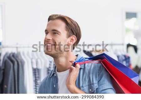 Portrait of a smiling man with shopping bags at the clothing store