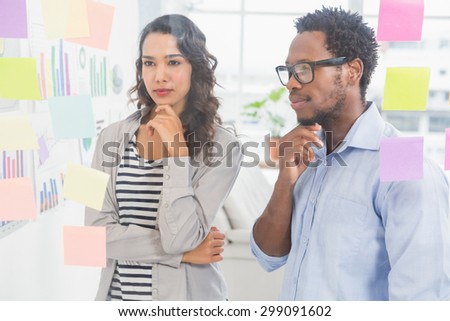Young creative business people at office looking at sticky notes