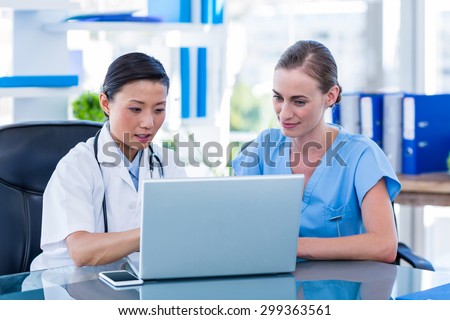 Doctor and nurse looking at laptop in medical office