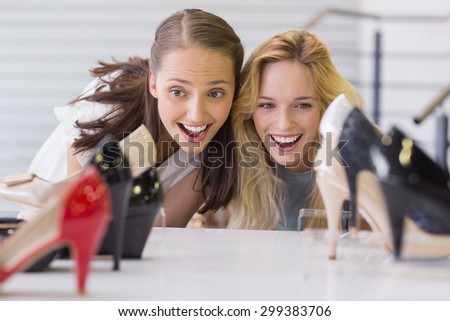 Two excited women looking at heel shoes in shoe store