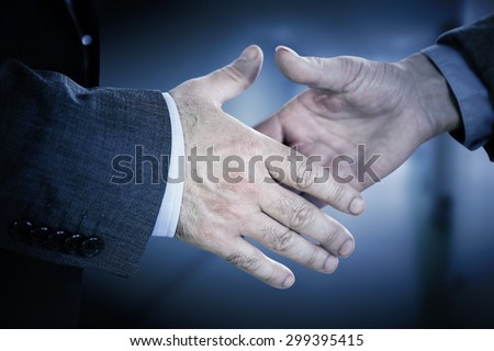 Two people going to shake their hands against college hallway