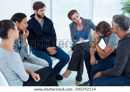 Concerned woman comforting another in rehab group at a therapy session