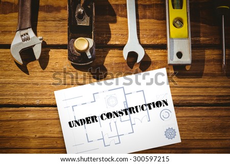 The word under construction and blueprint against white card