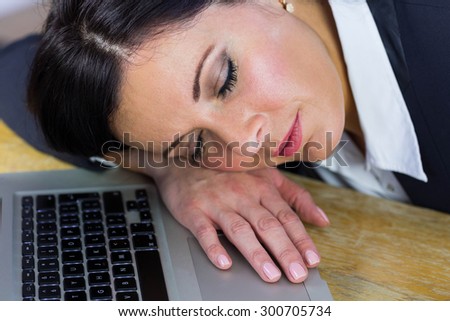 Businesswoman taking a nap on her desk in her office
