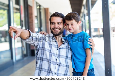 Son and father look away at the mall
