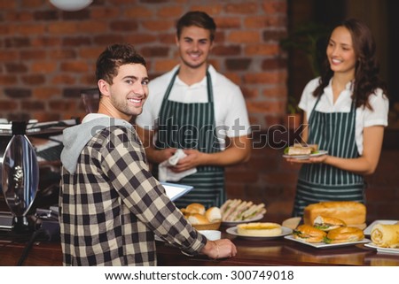Waiters and customer looking at the camera at the coffee shop