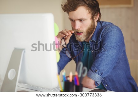 Focused hipster working at his desk in his office