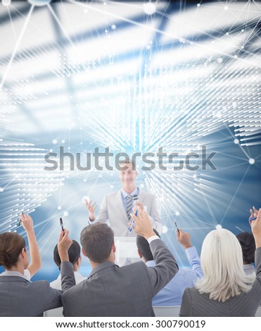 Business people raising their arms during meeting against glowing world map on black background