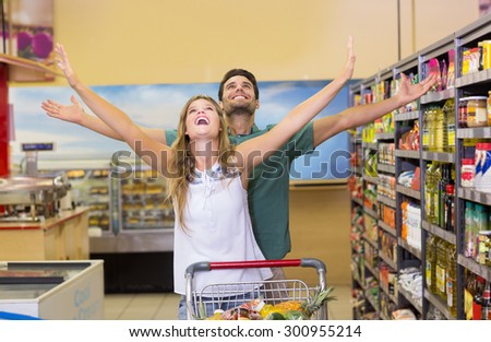 Happy bright couple buying food products at supermarket