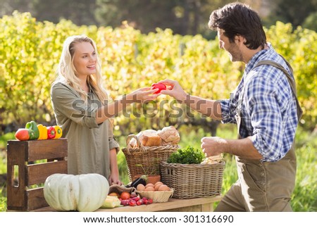 Smiling blonde customer discussing with the farmer