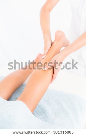 Female masseur massaging womans leg at spa center