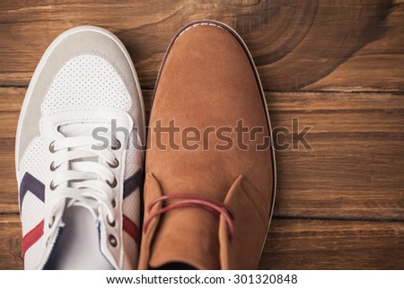 Casual and dressy mens shoes on wooden table