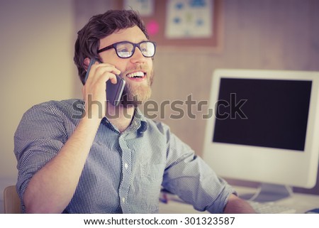 Hipster businessman on the phone at desk in his office