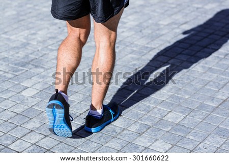Legs of an athlete running on a sunny day
