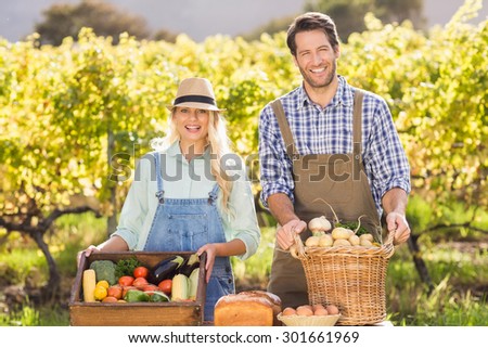 Portrait of a happy farmer couple presenting their local food