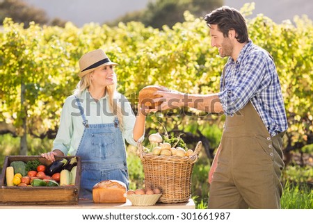 Happy farmer couple handing bread at the local market