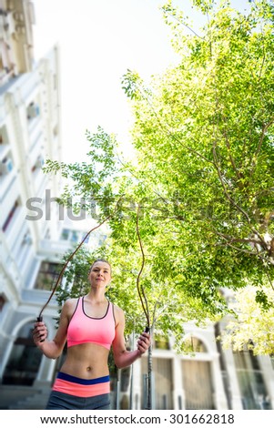 A pretty woman doing jumping rope on a sunny day