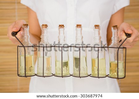 Close up view of woman holding bottles of oil massage