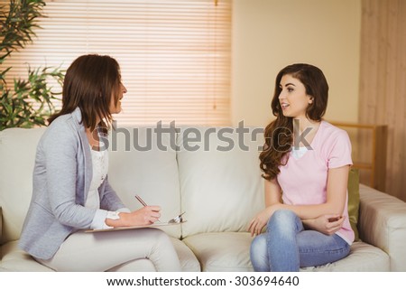 Therapist listening to her happy patient in therapists office